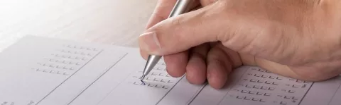 Photo: a hand writing on some forms
