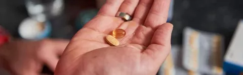 A person holding some pills to demonstrate drugs and medicine as a type of MS treatment