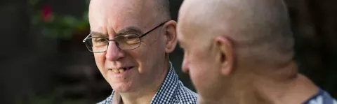 A photo of two men talking outside