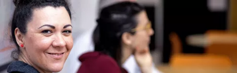 Photo: a woman in a meeting smiling at the camera