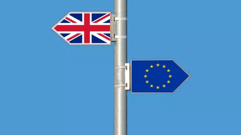 Signpost showing Union Jack flag and EU flag