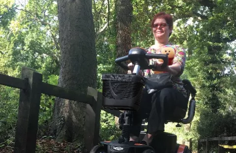 Caroline from Kent, on her mobility scooter in the woods