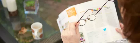 lady with ms putting on her glasses to help with eye pain and vision problems