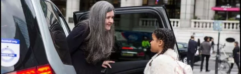 a photo of a Woman getting out of car with her daughter