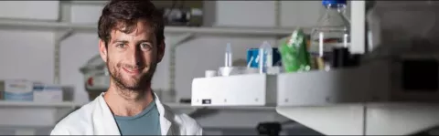 Photo: Researcher working in the lab and smiling at the camera