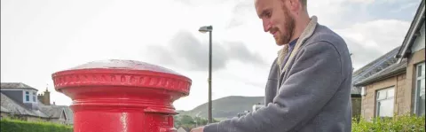 Man dropping off used postage stamps for recycling