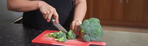 A woman preparing vegetables in a kitchen