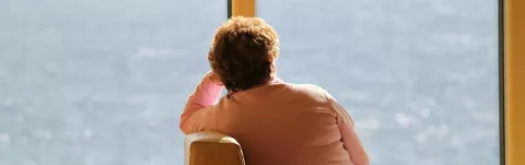 Woman staring out of the window representing a person with MS who has depression
