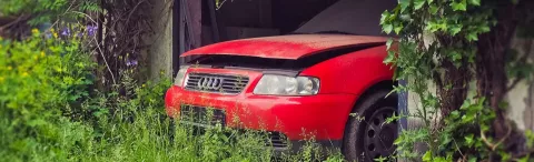 a red car in a garage in a field
