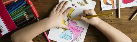 Child colouring a picture and being happy in their life, demonstrating the importance of explaining MS to children