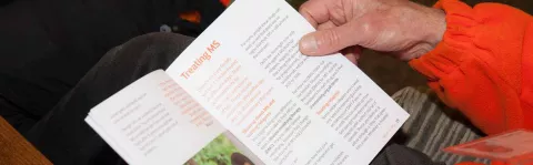 Photo: Man reading MS information booklet closeup