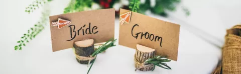 Bride and Groom place names on wedding table with MS Society logos