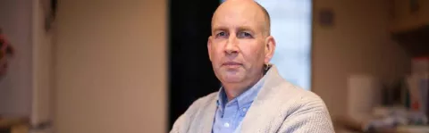 Image show a man with MS at home looking sad