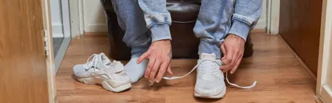 a photo of a man Tying shoe laces