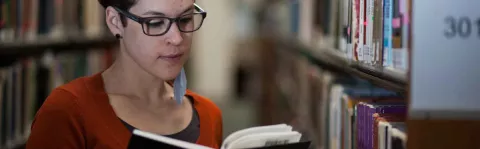 Photo: Woman with MS reading in the library
