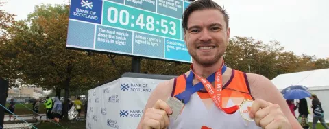 image shows a runner smiling with medals