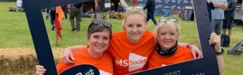 Group of people smiling while taking part in a local MS walking challenge
