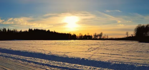 The sun sets over a field of snow