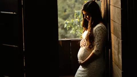 A pregnant woman holding her stomach