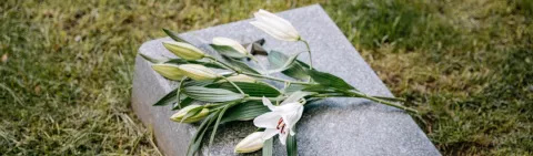 A simple flat gravestone with lillies on top