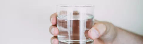 a glass of water being held up