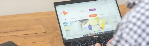 The photo shows Nick Moberly looking at the MS Society website on a laptop