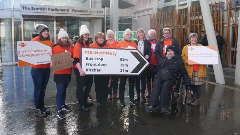  A group of MS Society campaigners holding placards for a PIP campaign